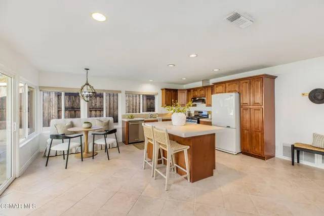 a living room with furniture a dining table and chairs with kitchen view