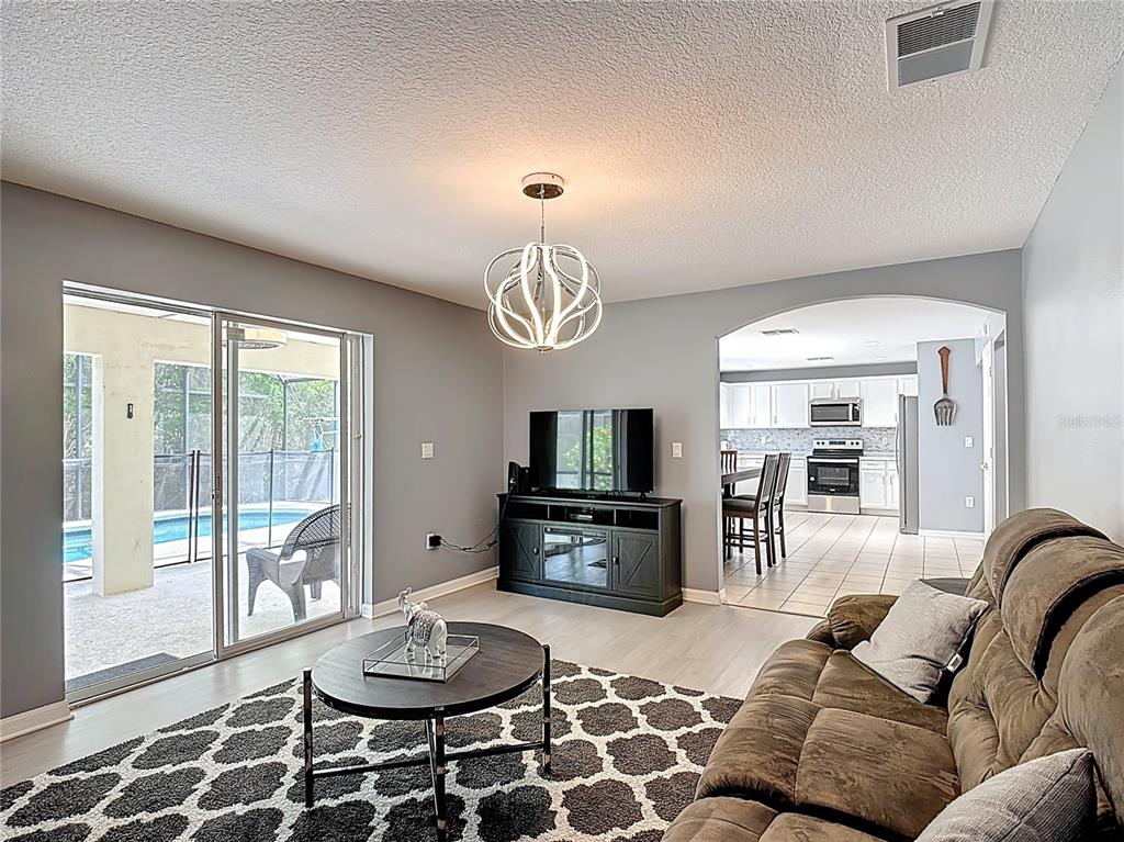 320 Mockingbird Road Davenport, FL 33896 - Photo 11 of 34 a living room with furniture a flat screen tv and a table