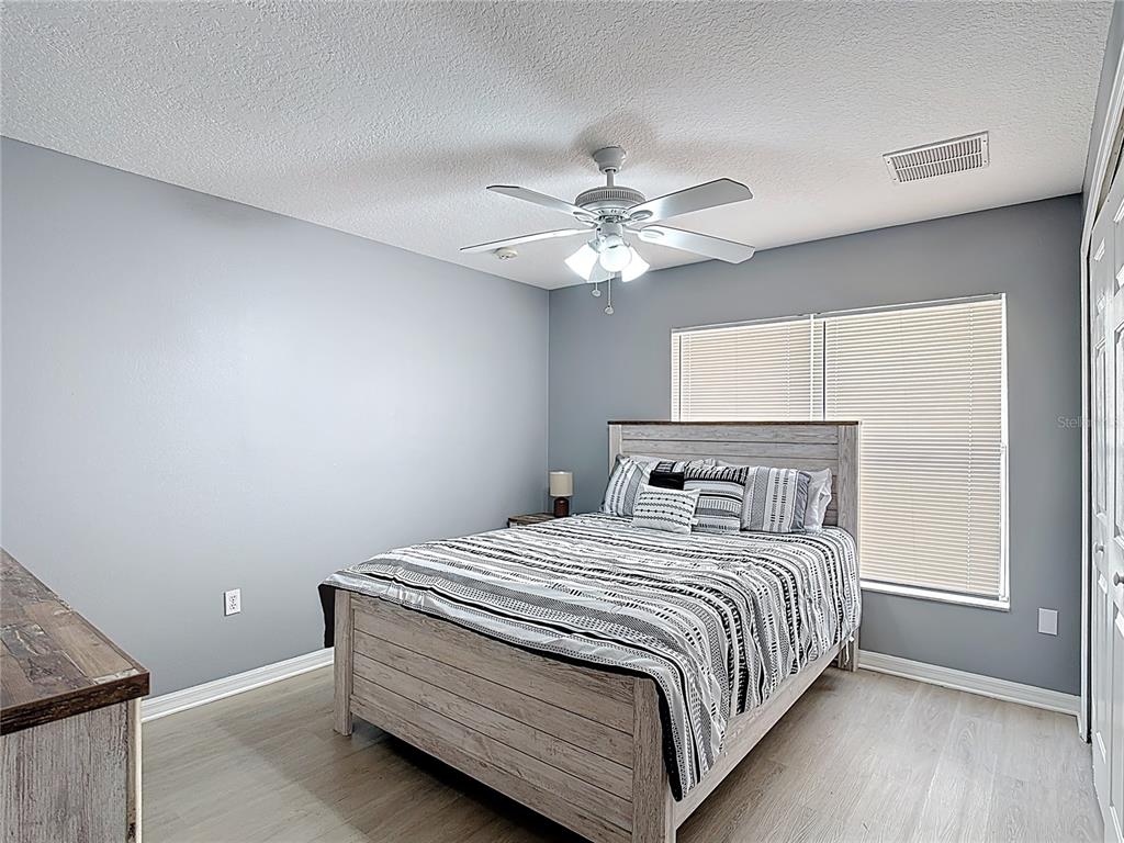 320 Mockingbird Road Davenport, FL 33896 - Photo 12 of 34 a bedroom with a bed chandelier and a window