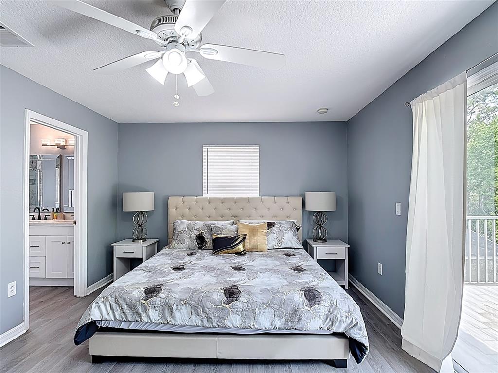 320 Mockingbird Road Davenport, FL 33896 - Photo 15 of 34 a bedroom with a large bed and a chandelier