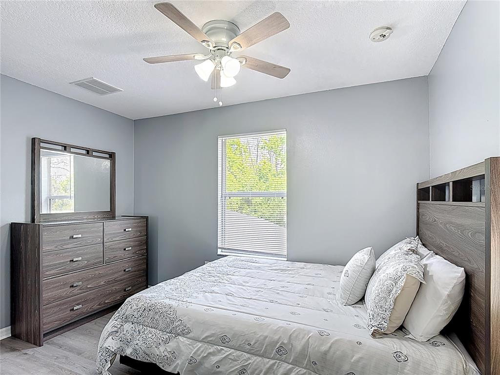 320 Mockingbird Road Davenport, FL 33896 - Photo 21 of 34 a bedroom with a bed and a dresser