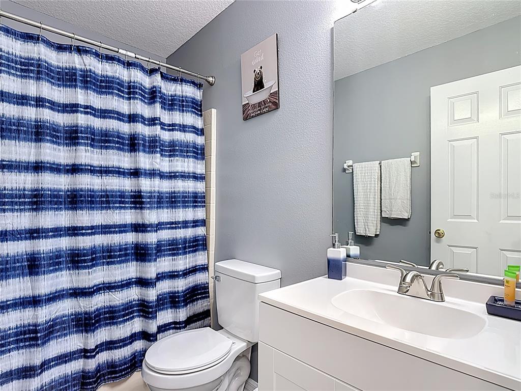320 Mockingbird Road Davenport, FL 33896 - Photo 22 of 34 a bathroom with a sink a toilet and shower curtain