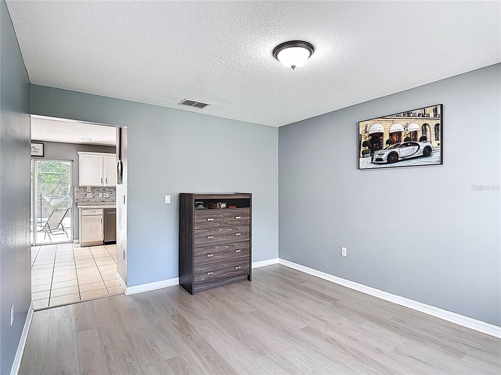 320 Mockingbird Road Davenport, FL 33896 - Photo 4 of 34 an empty room with wooden floor and windows