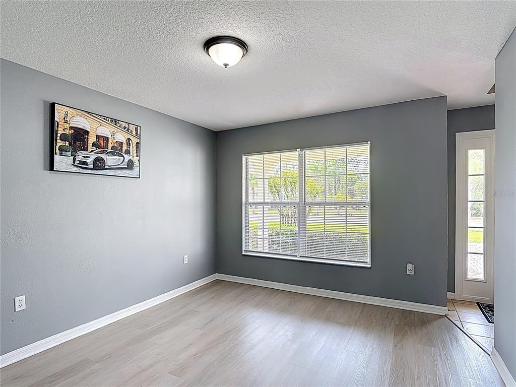 320 Mockingbird Road Davenport, FL 33896 - Photo 5 of 34 an empty room with wooden floor and windows