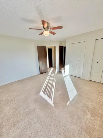 a view of wooden floor and chandelier fan in a room
