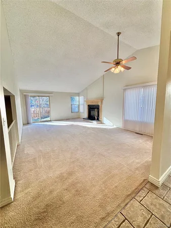 a view of an empty room with window and chandelier