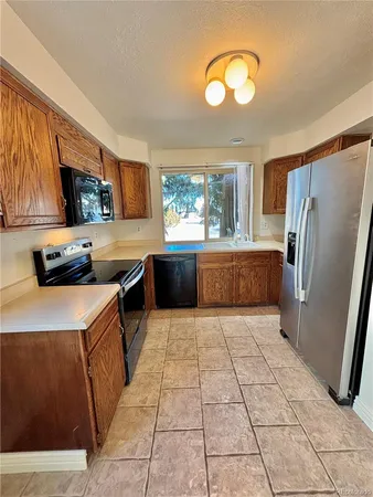 a kitchen with stainless steel appliances granite countertop a refrigerator a stove a sink and a microwave