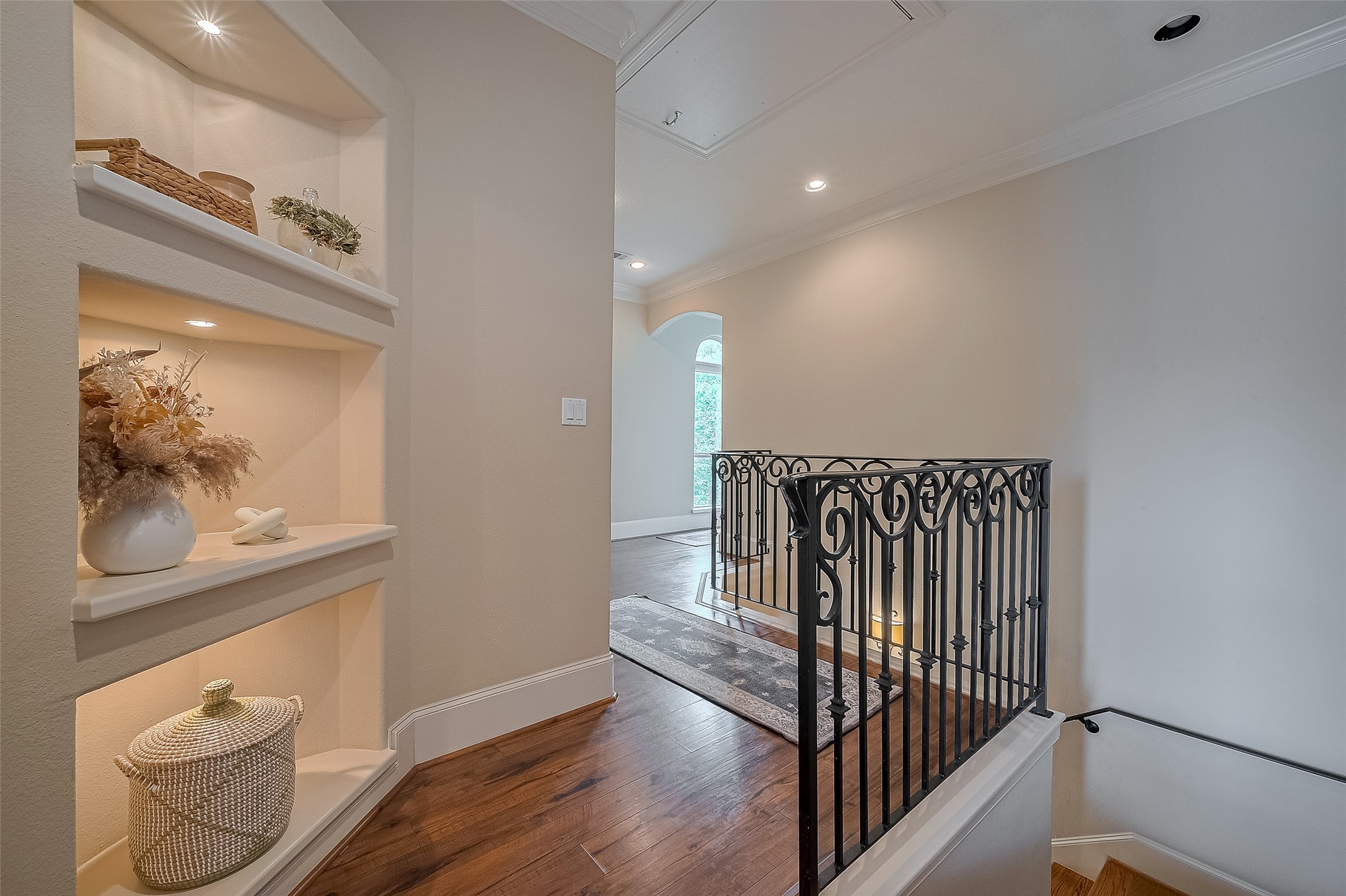 6419 Rodrigo Street Houston, TX 77007 - Photo 26 of 35 At the top of the stairs is a great hall space with thoughtful built in accent shelving, leading towards the utility space and primary bedroom.