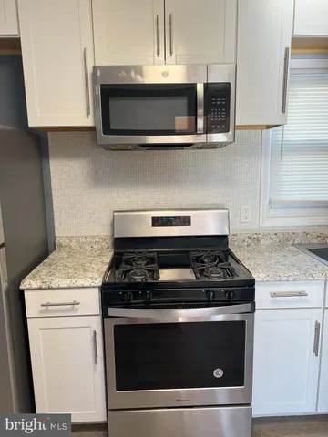 a stove top oven sitting inside of a kitchen
