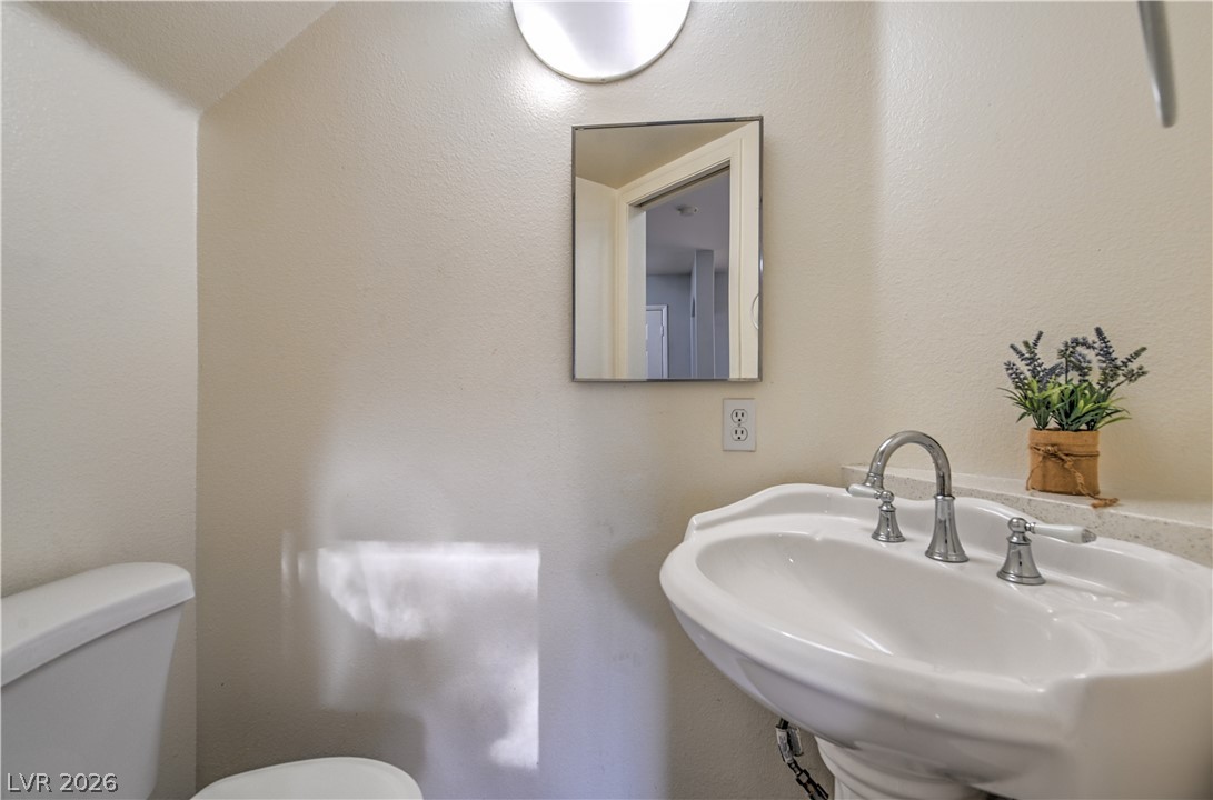 3950 South Sandhill Road, Unit 112 Las Vegas, NV 89121 - Photo 12 of 33 Half bathroom featuring a sink and toilet