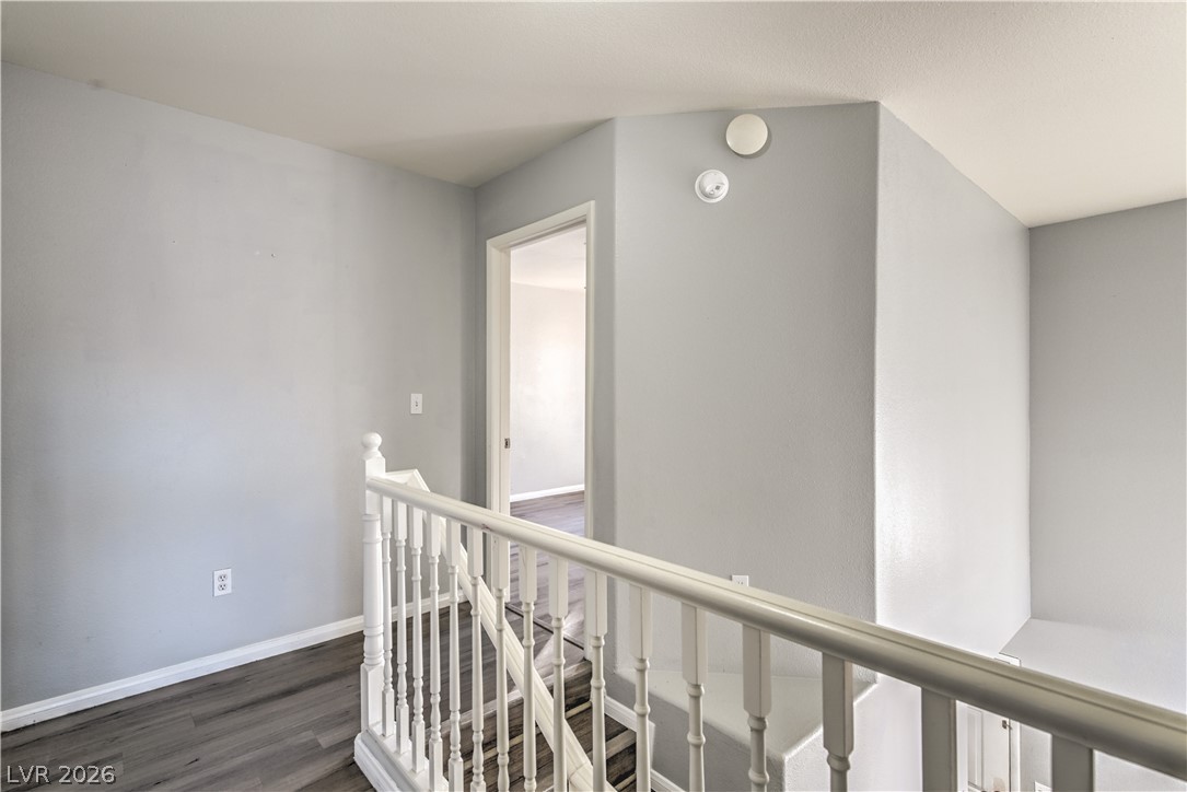3950 South Sandhill Road, Unit 112 Las Vegas, NV 89121 - Photo 13 of 33 Hall featuring an upstairs landing, dark wood-style floors, and baseboards