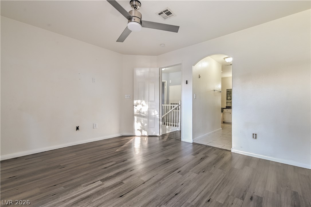 3950 South Sandhill Road, Unit 112 Las Vegas, NV 89121 - Photo 16 of 33 Spare room with baseboards, arched walkways, visible vents, a ceiling fan, and wood finished floors