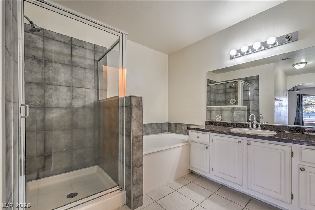 3950 South Sandhill Road, Unit 112 Las Vegas, NV 89121 - Photo 18 of 33 Bathroom with tile patterned floors, vanity, a stall shower, and a garden tub