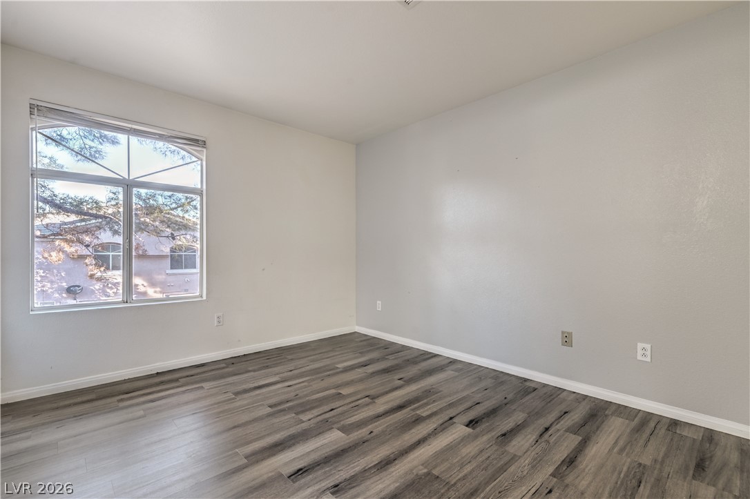 3950 South Sandhill Road, Unit 112 Las Vegas, NV 89121 - Photo 20 of 33 Empty room featuring baseboards and wood finished floors