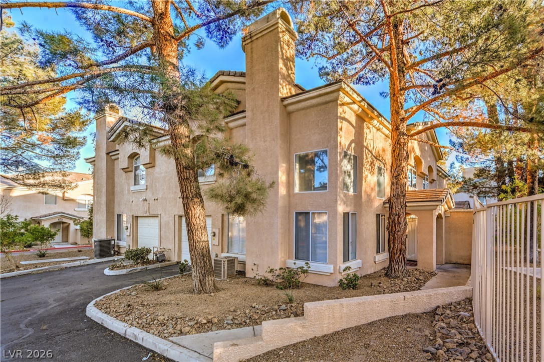 3950 South Sandhill Road, Unit 112 Las Vegas, NV 89121 - Photo 32 of 33 View of property featuring central AC unit, an attached garage, and fence