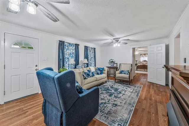 a living room with furniture and a wooden floor