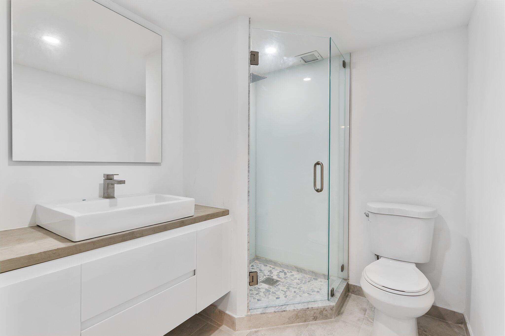 6 Royal Palm Way, Unit 509 Boca Raton, FL 33432 - Photo 13 of 23 a bathroom with a toilet sink shower and mirror