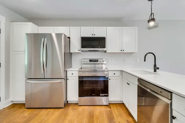 a kitchen with a refrigerator sink and cabinets