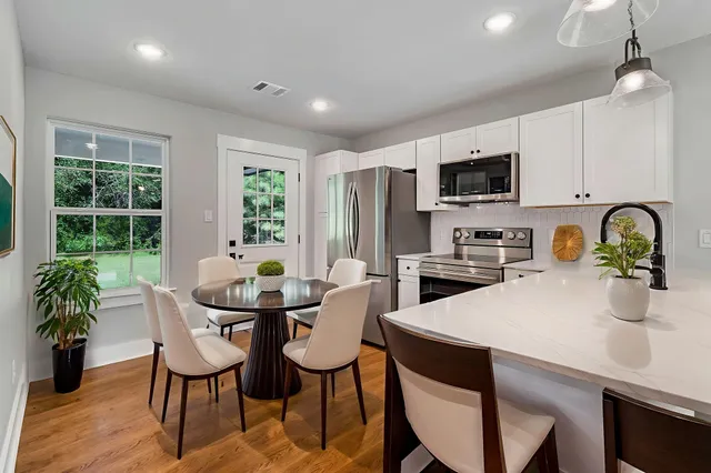 a kitchen with a table chairs refrigerator and microwave