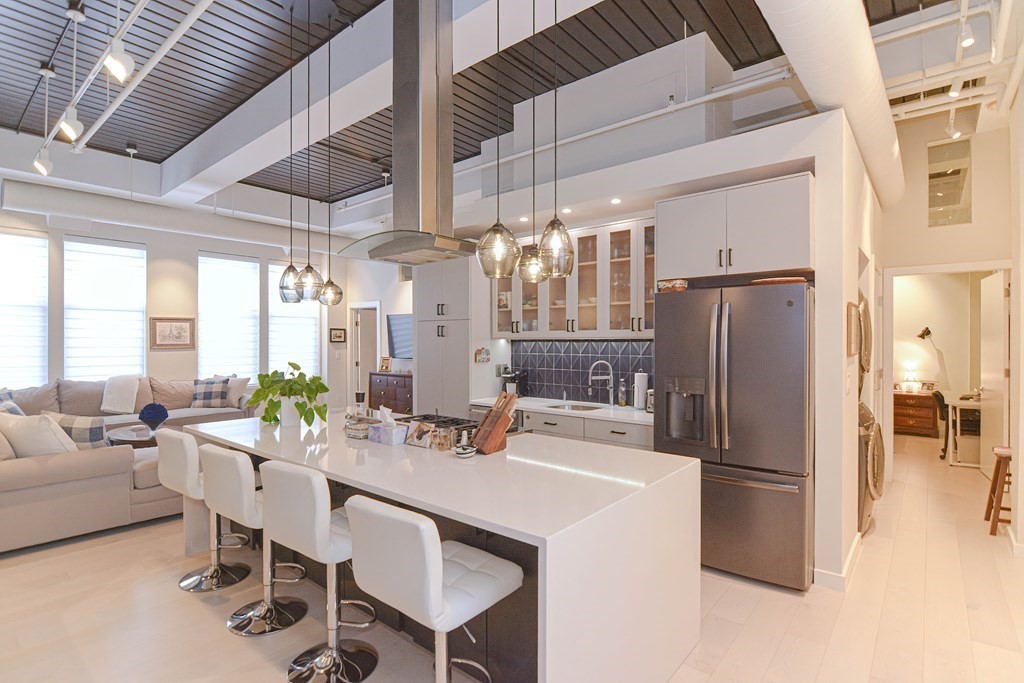 a kitchen with stainless steel appliances a refrigerator a table and chairs