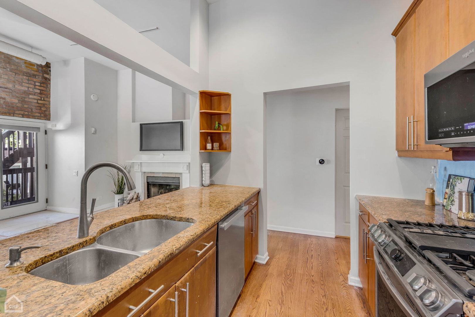 1001 West Altgeld Street, Unit 3 Chicago, IL 60614 - Photo 5 of 18 a kitchen with granite countertop a sink a stove and wooden floor