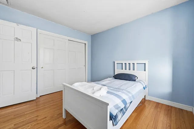 a bedroom with a bed and wooden floor