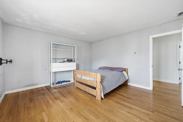 a room with a bed and wooden floor