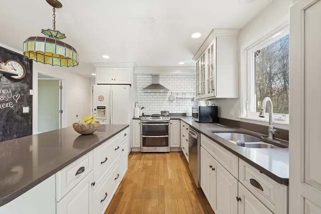 a large kitchen with stainless steel appliances granite countertop a lot of counter space and wooden floors