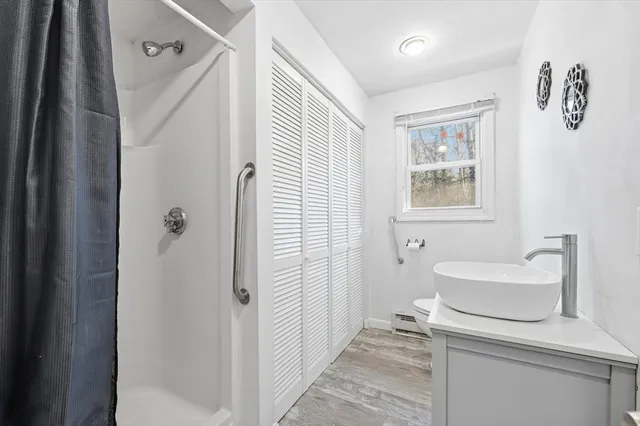 a bathroom with a sink a toilet and shower