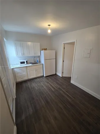 a kitchen with cabinets and wooden floor