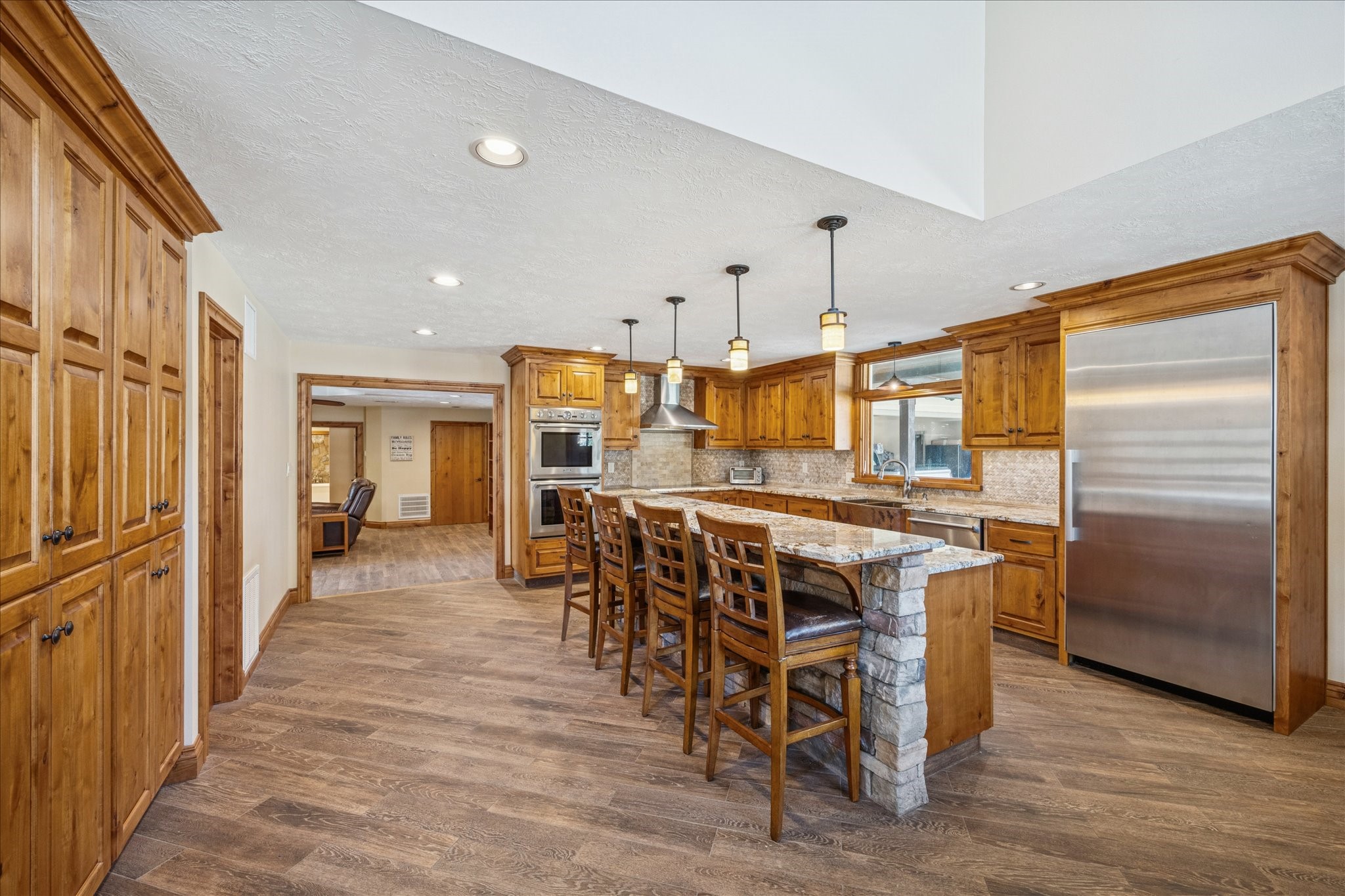 640 Piney Creek Road Bellville, TX 77418 - Photo 7 of 35 a view of a kitchen with kitchen island granite countertop wooden floors and a view of living room