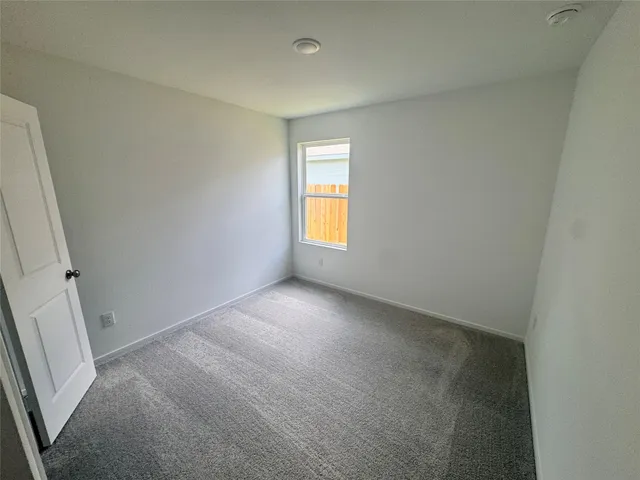 an empty room with window and closet area
