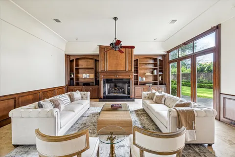a living room with fireplace furniture and a large window