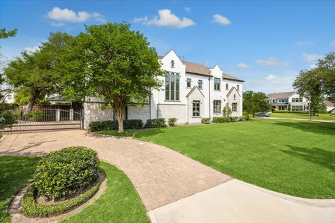 a view of a white house with a big yard and potted plants