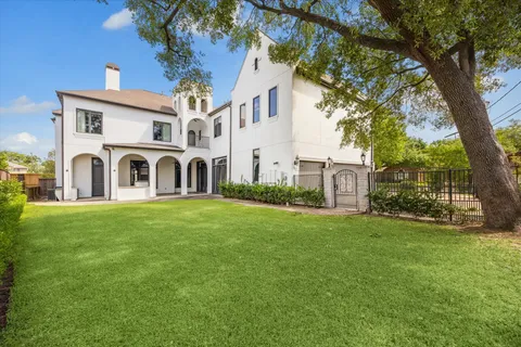 a view of a white house with a big yard and large trees