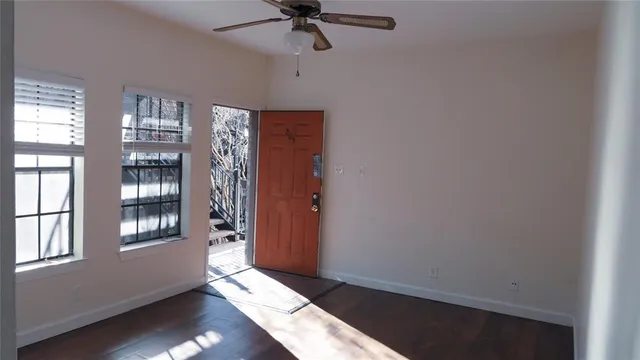 an empty room with windows and cabinet