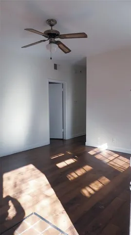 a view of a room with a ceiling fan and window