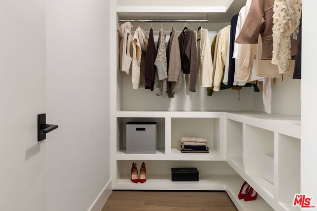 a view of walk in closet with clothes and shoes