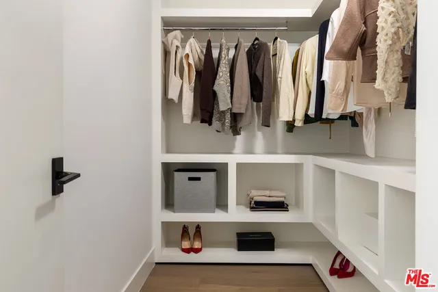 a view of walk in closet with clothes and shoes