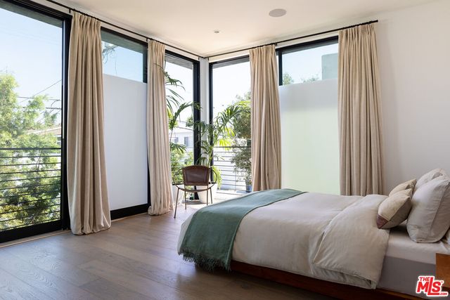 a bedroom with a bed and a large window