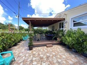 2221 Southwest 26th Lane Miami, FL 33133 - Photo 3 of 13 a view of a patio with table and chairs potted plants with wooden fence