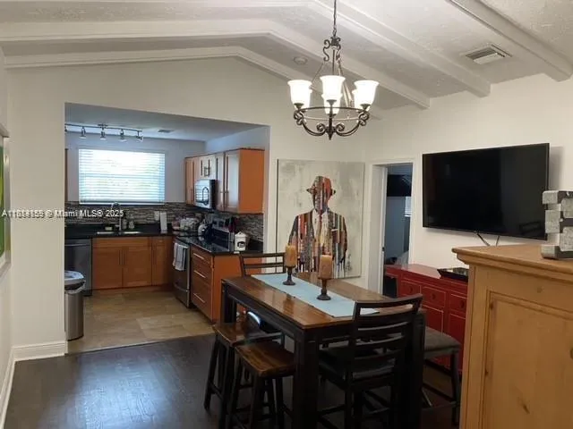 a kitchen with granite countertop a refrigerator stove and sink