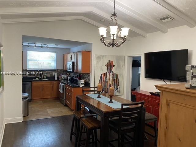 2221 Southwest 26th Lane Miami, FL 33133 - Photo 6 of 13 a view of a dining room with furniture a chandelier and wooden floor