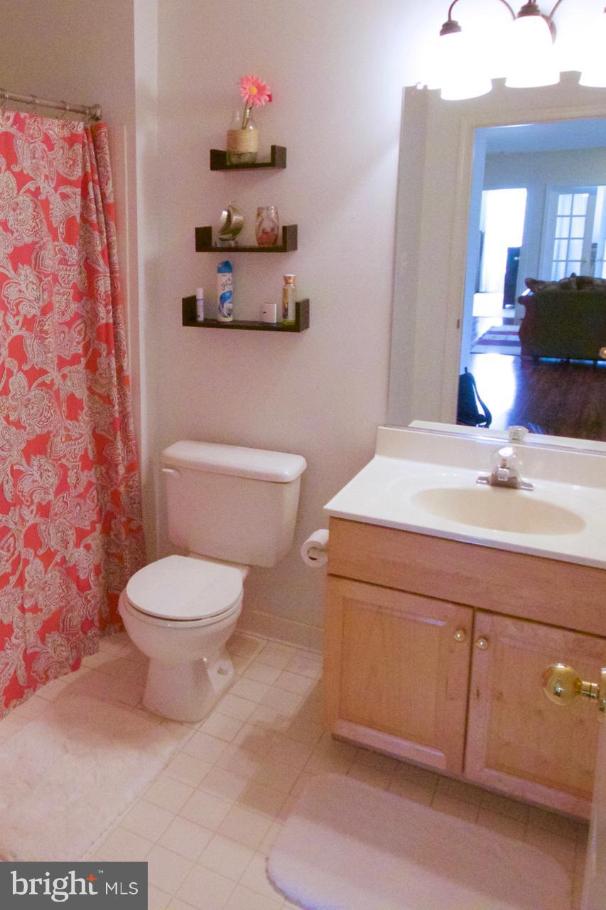 25252 Riffleford Square, Unit 101 Chantilly, VA 20152 - Photo 12 of 30 a bathroom with a sink a toilet and a mirror