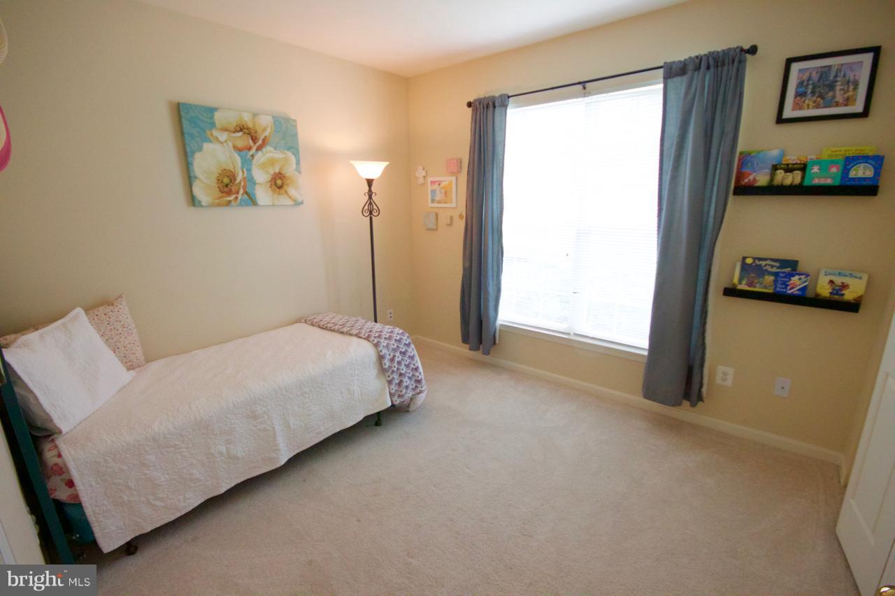 25252 Riffleford Square, Unit 101 Chantilly, VA 20152 - Photo 13 of 30 a bed room with a bed and a couch