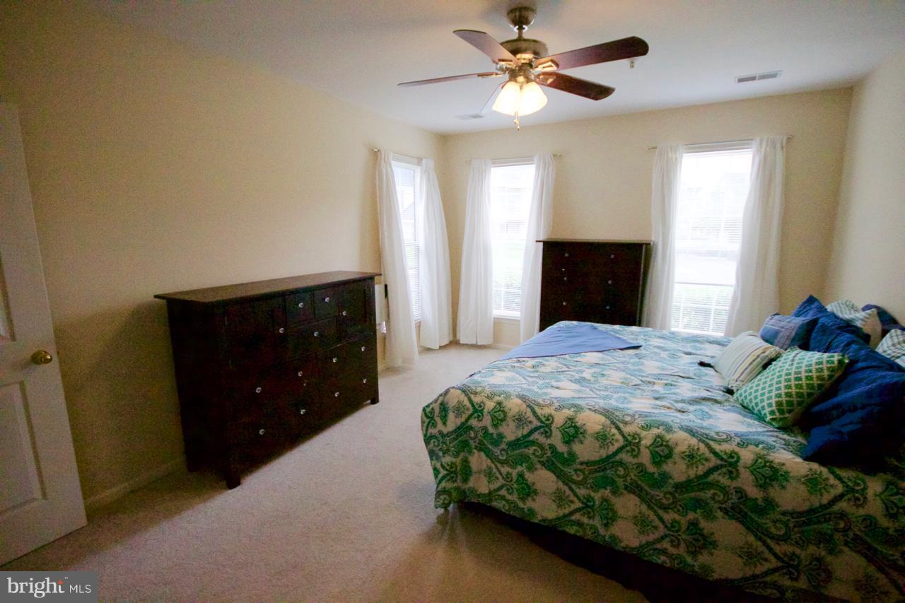 25252 Riffleford Square, Unit 101 Chantilly, VA 20152 - Photo 15 of 30 a bedroom with a bed and a dresser