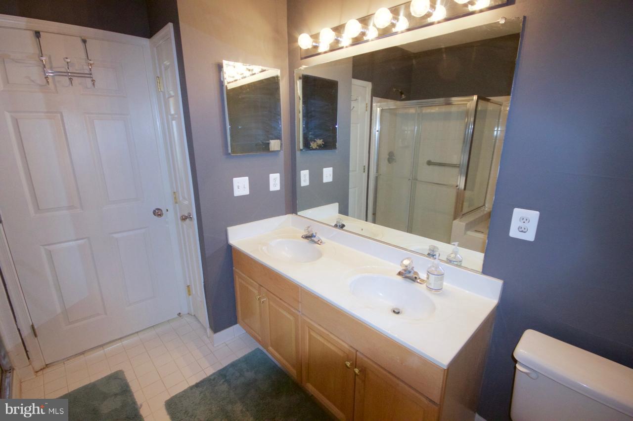 25252 Riffleford Square, Unit 101 Chantilly, VA 20152 - Photo 18 of 30 a bathroom with a sink a toilet and shower