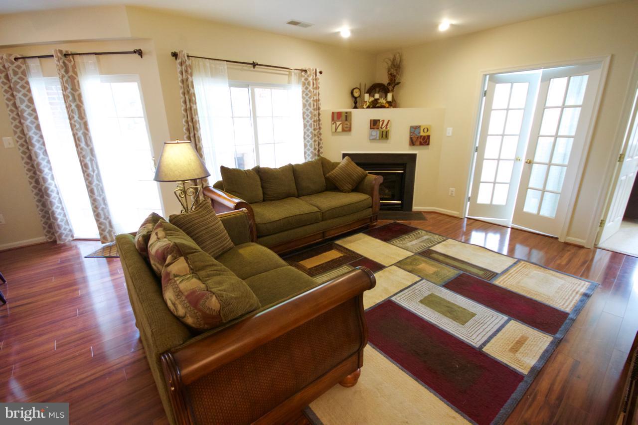 25252 Riffleford Square, Unit 101 Chantilly, VA 20152 - Photo 4 of 30 a living room with furniture and a fireplace