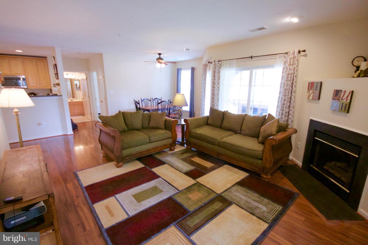 25252 Riffleford Square, Unit 101 Chantilly, VA 20152 - Photo 6 of 30 a living room with furniture a couch and wooden floor