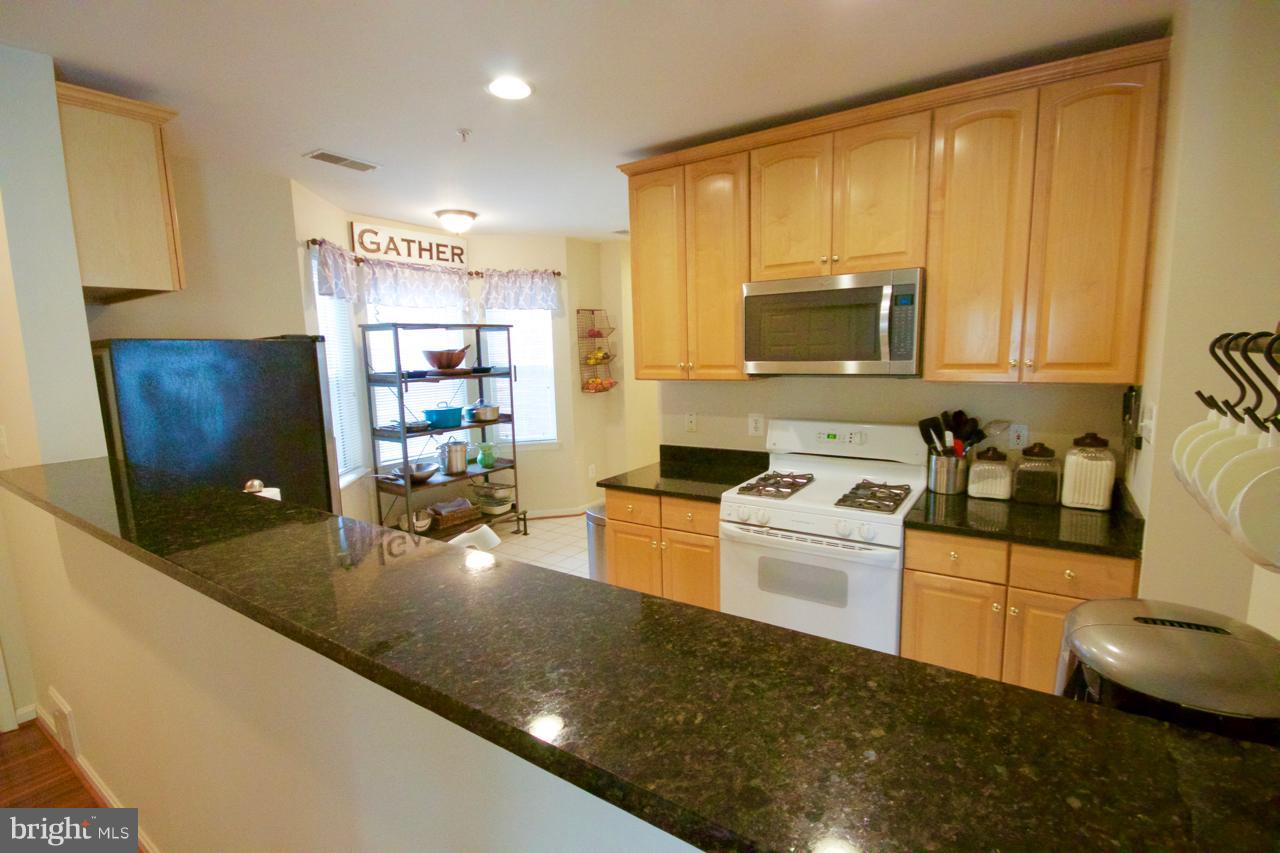 25252 Riffleford Square, Unit 101 Chantilly, VA 20152 - Photo 7 of 30 a kitchen with a sink a stove and cabinets